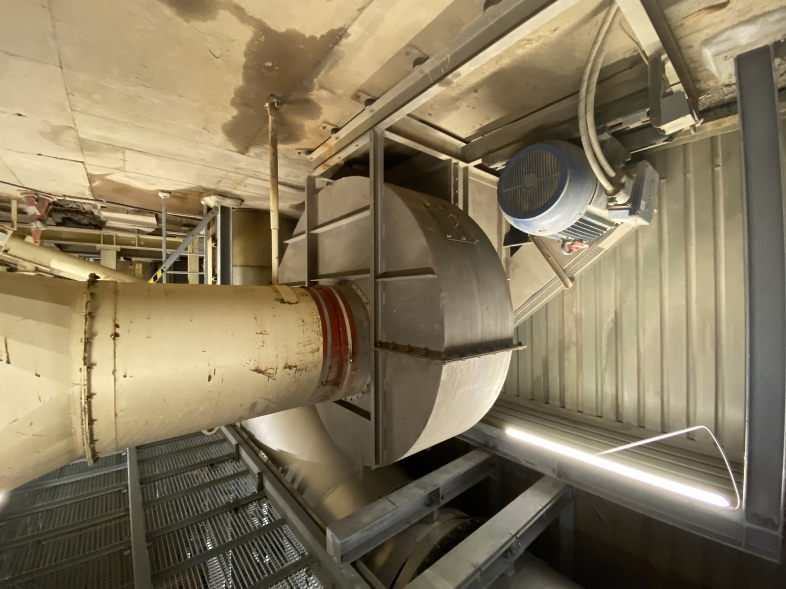 Grote radiaalventilator met elektromotor en luchtkanaal in een industriële installatie